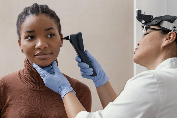 doctora revisando los oídos de una paciente de raza negra