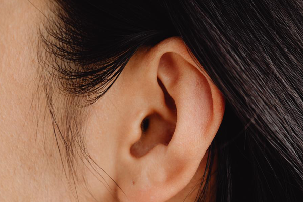 plano cercano de un oído de mujer con cabello negro